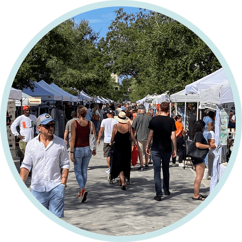 Busy outdoor street market with white vendor tents